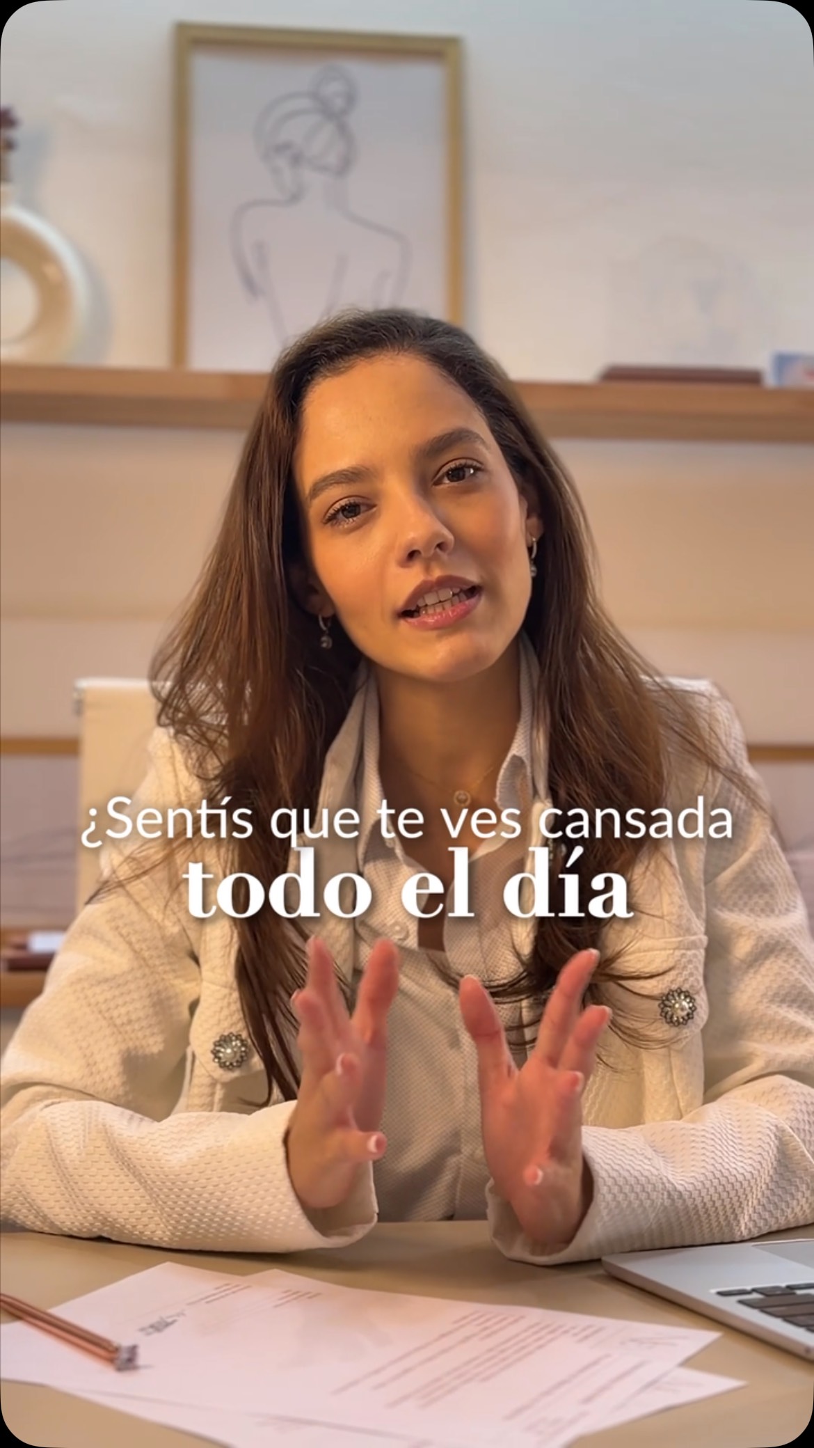 La Dra. María Eduarda Peres explica sentada a su escritorio, con estantes de madera detrás